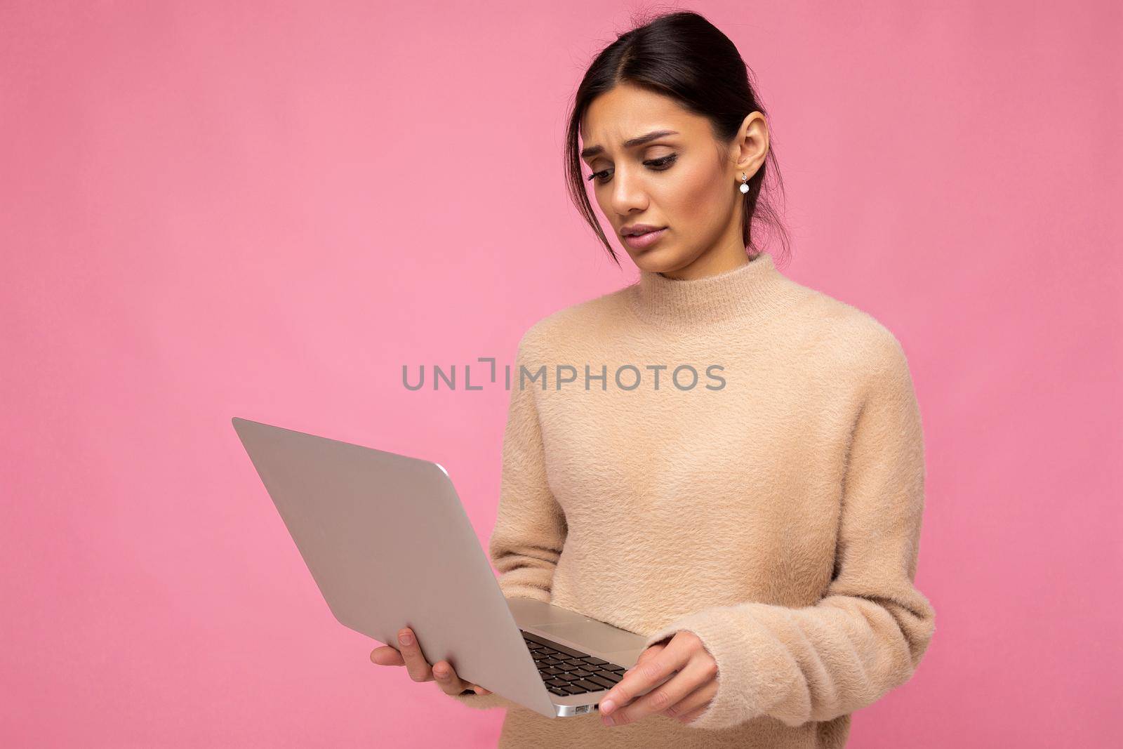 side profile photo of charming pretty sad young lady holding laptop isolated over wall background looking down at netbook.