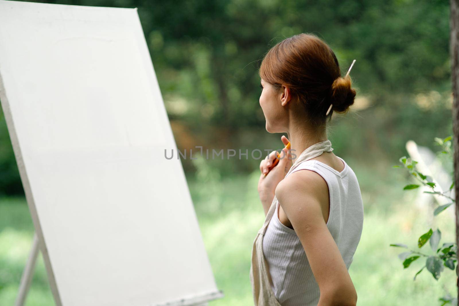 woman outdoors painting a picture easel art hobby. High quality photo