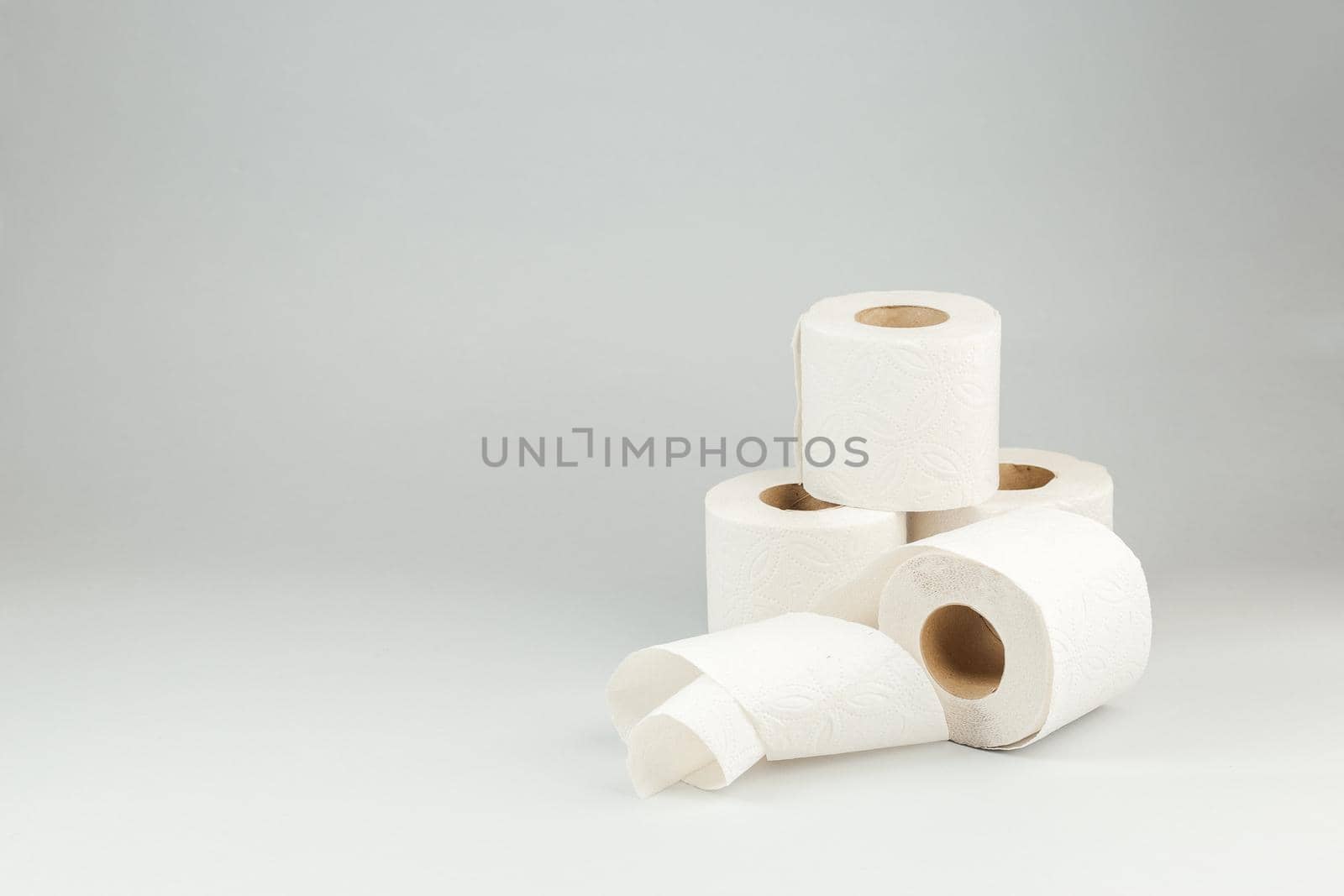 Rolls of Soft White Toilet Paper over Gray Background. Hygiene concept. Copy Space for text