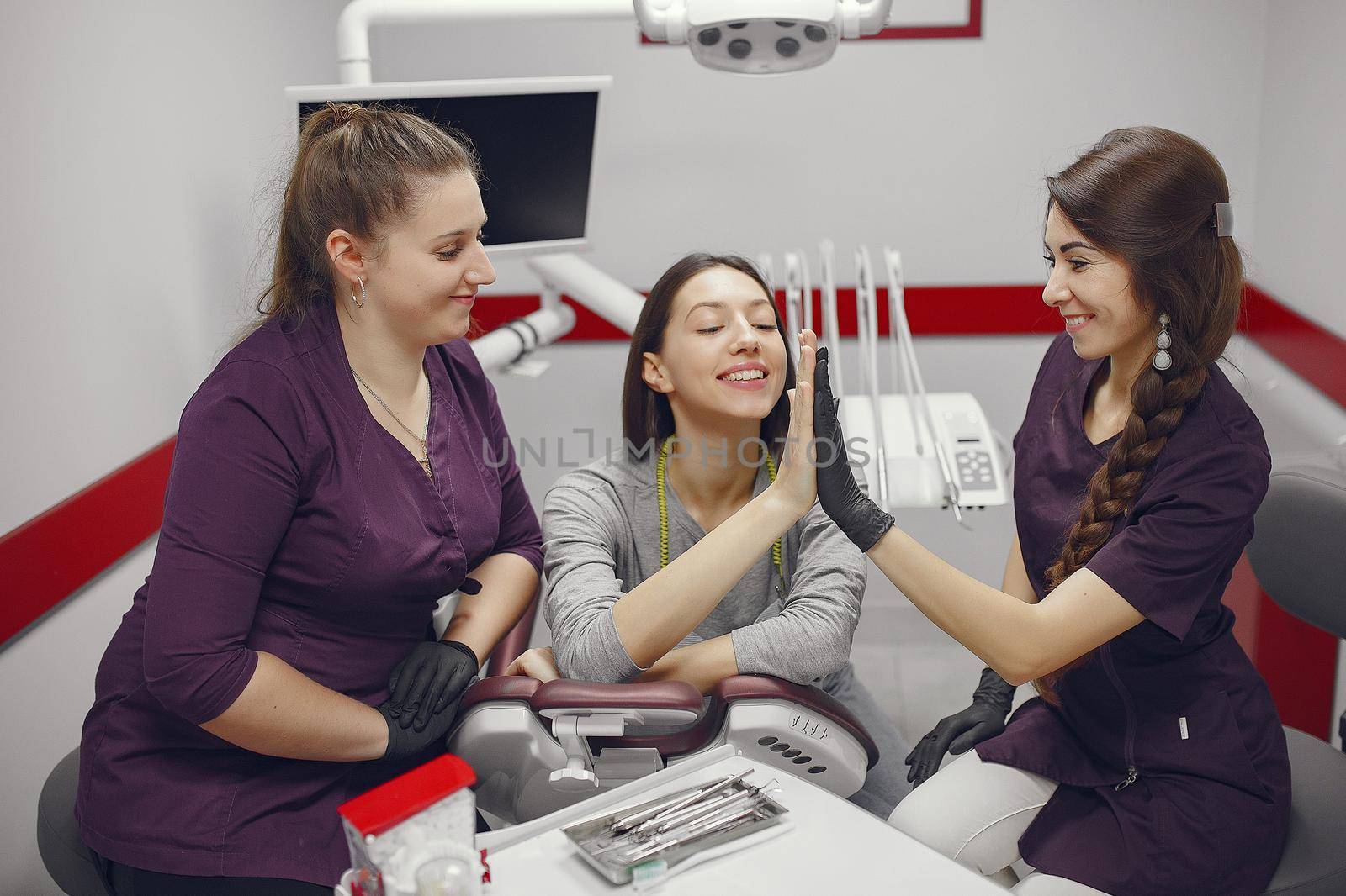 Beautiful lady in the dentist's office. Woman in a purple uniform