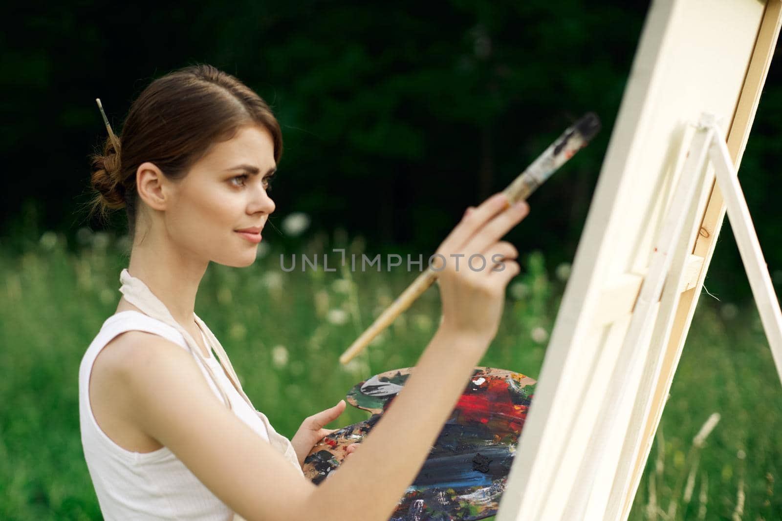 cheerful woman artist painting a picture outdoors creative art by Vichizh