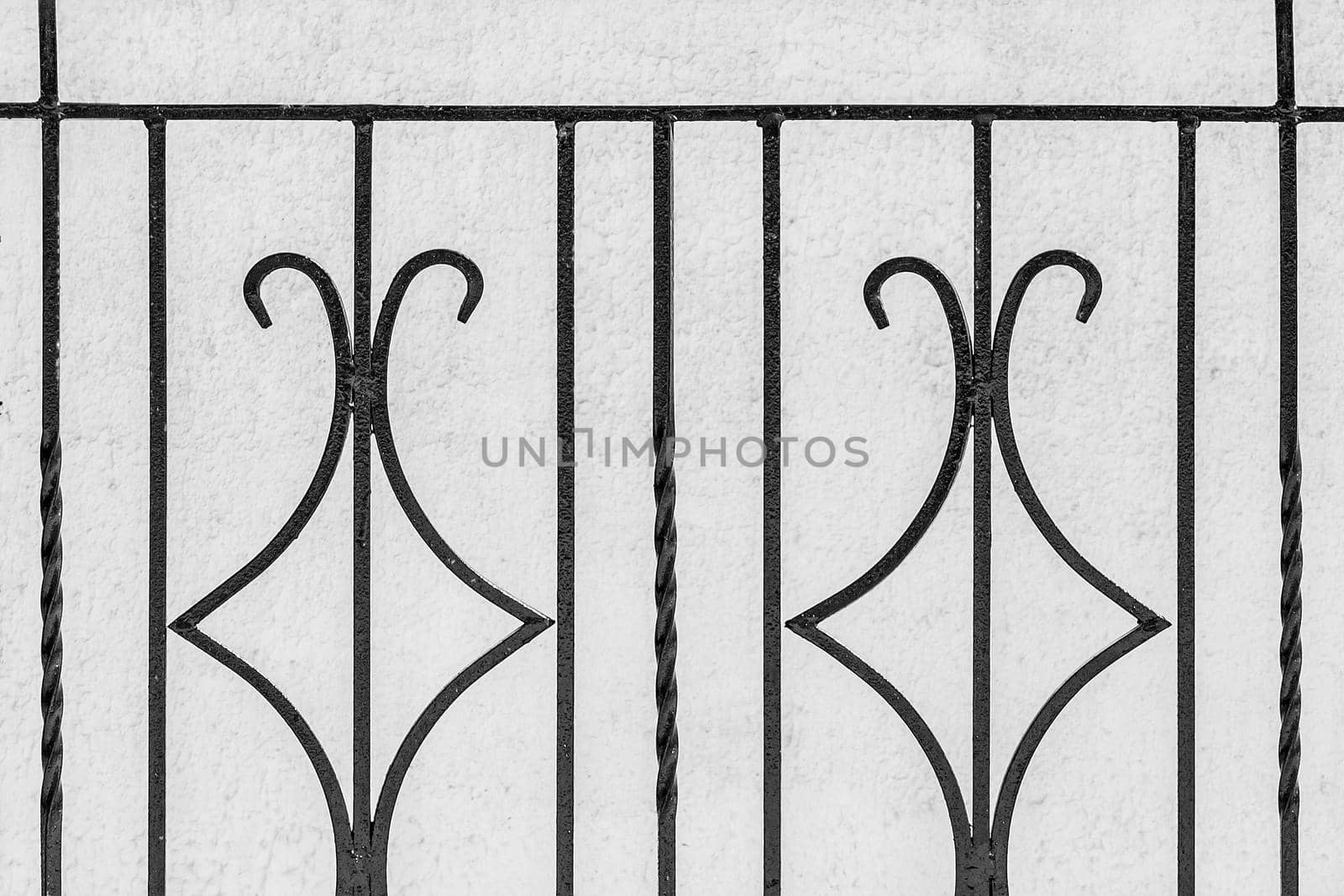 Iron black architectural geometric element, decorative fence lattic on white wall background.