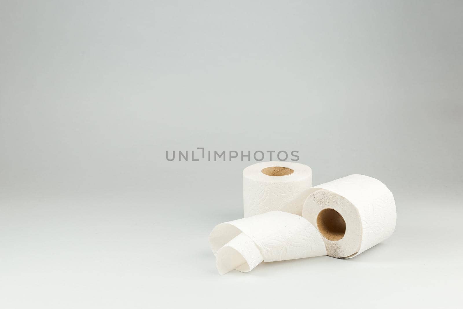 Two Rolls of White Toilet Paper over Gray Background. Copy Space for text
