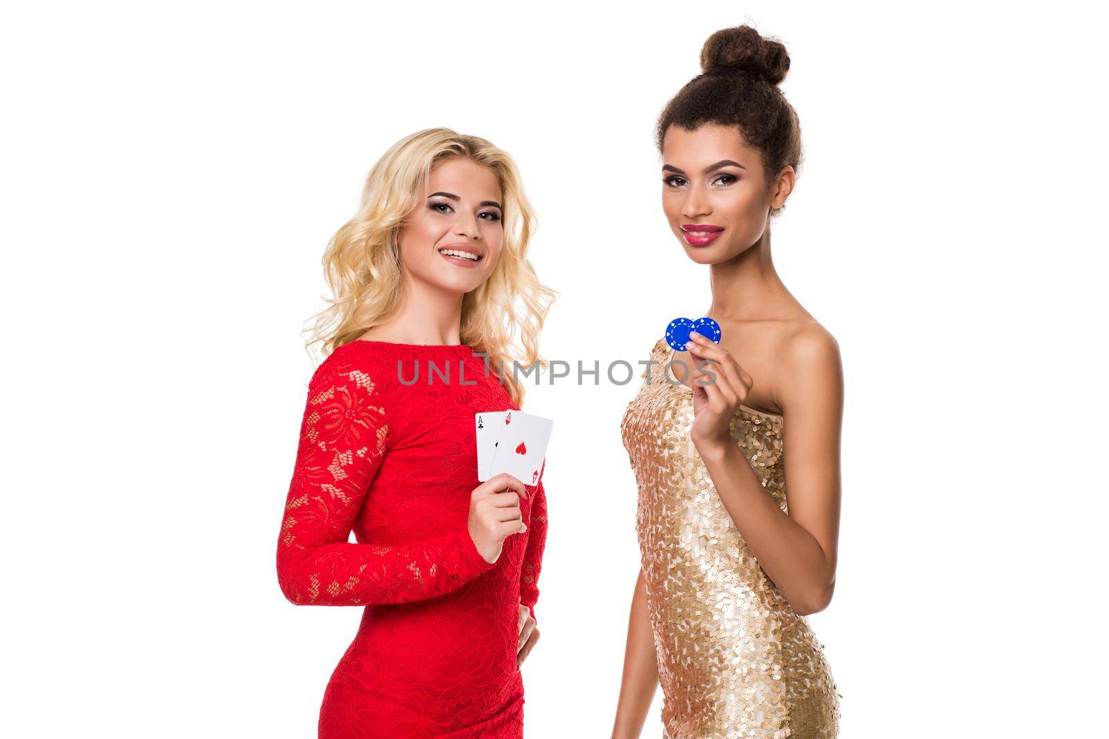 Beautiful african woman and Caucasian young woman with long light blonde hair in evening outfit. Holding playing cards and chips. Isolated on white background. Poker