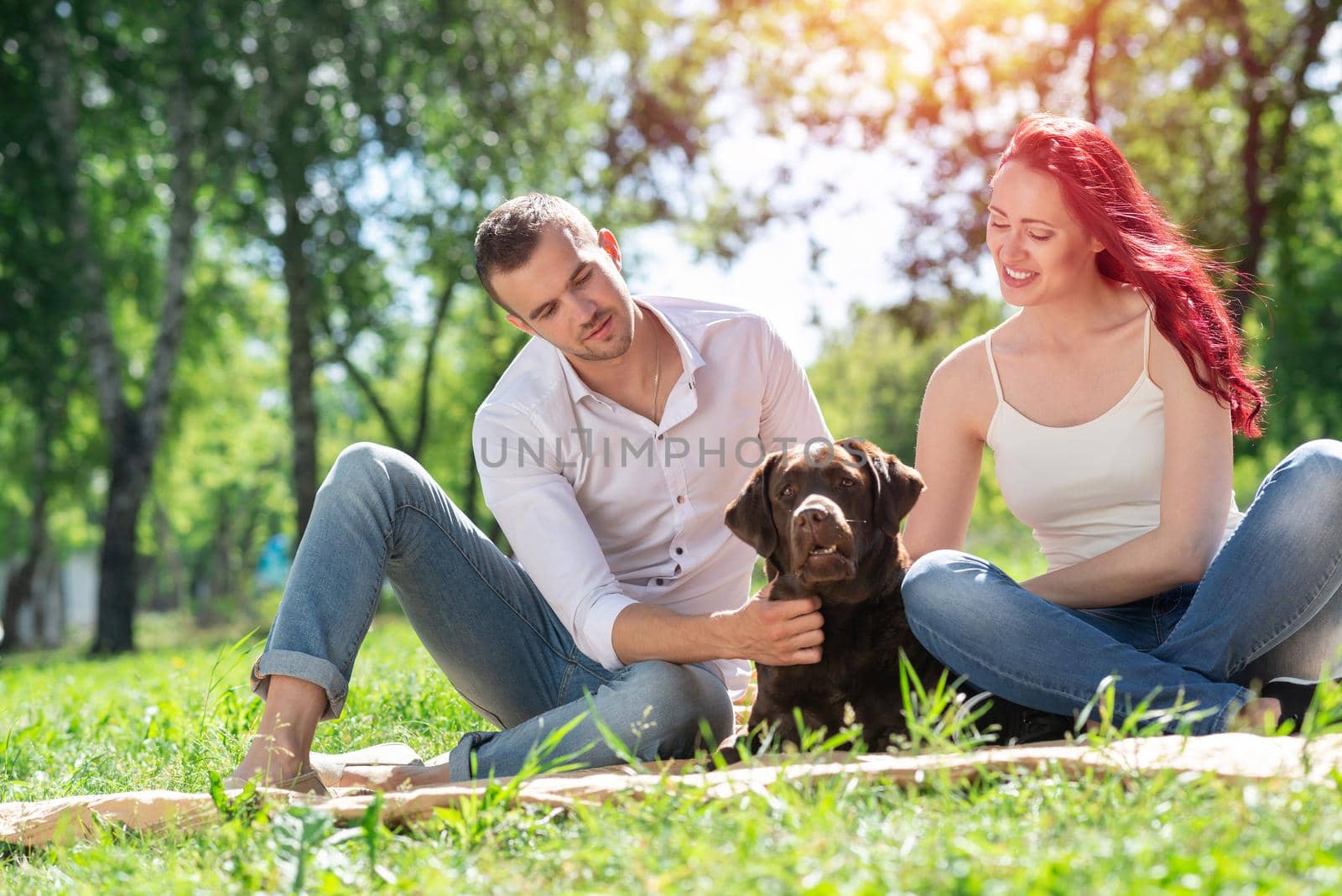 A couple and their dog in the park. Spending time with friends