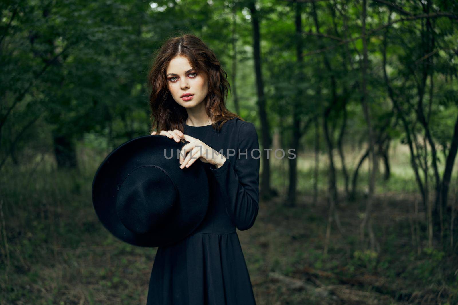 woman in black dress in the forest Halloween Witch costume. High quality photo