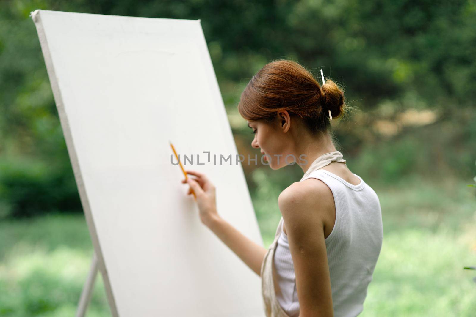 woman outdoors painting a picture easel art hobby by Vichizh