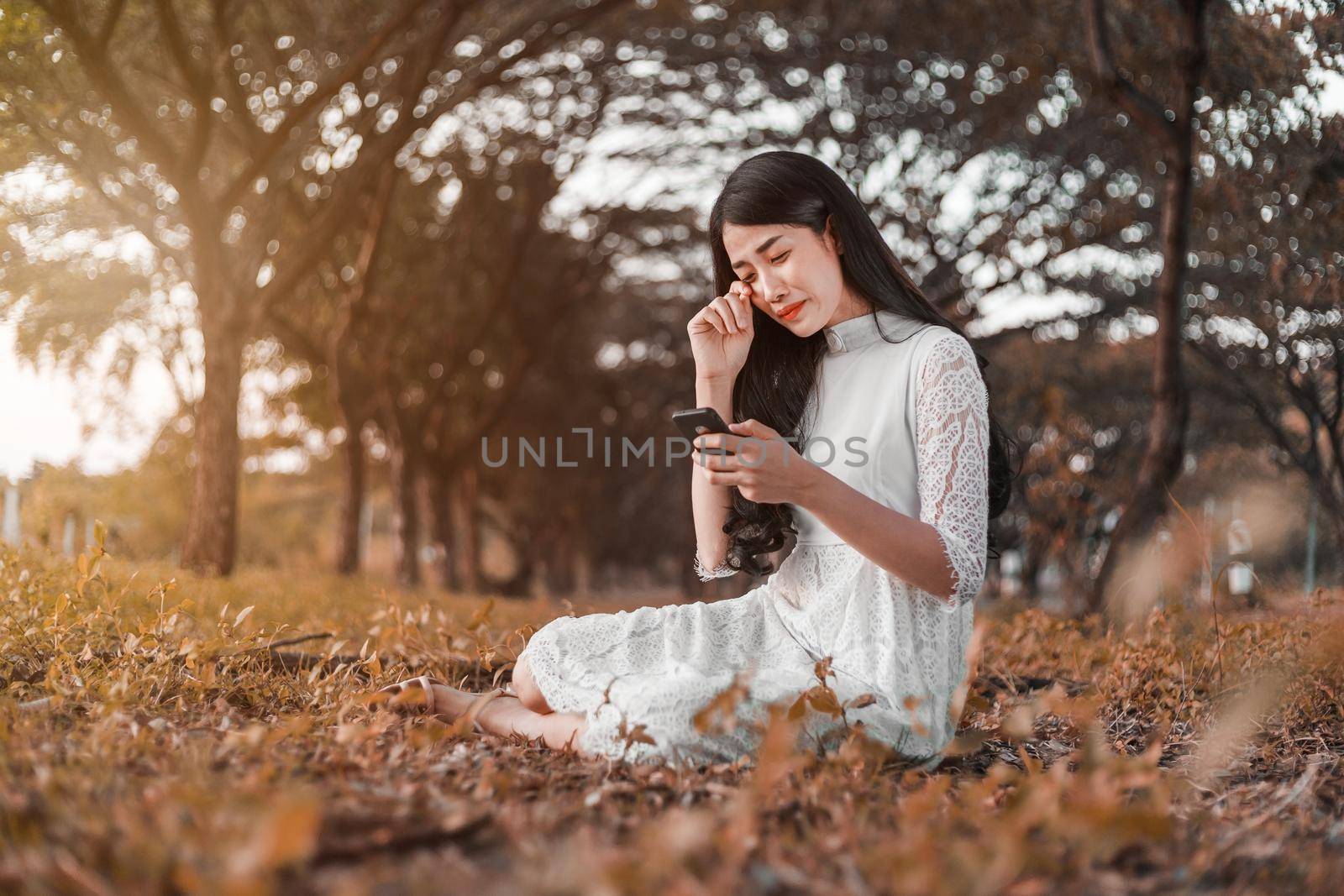 sad woman calling on mobile phone in the park