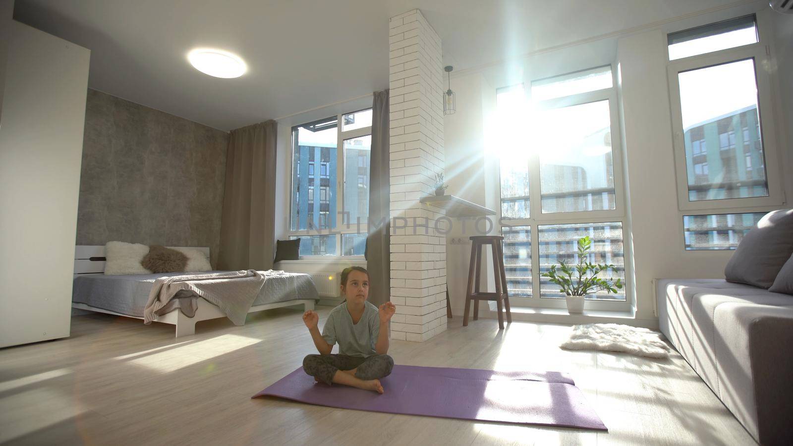 little cute girl do a yoga at home with space for add text by Andelov13