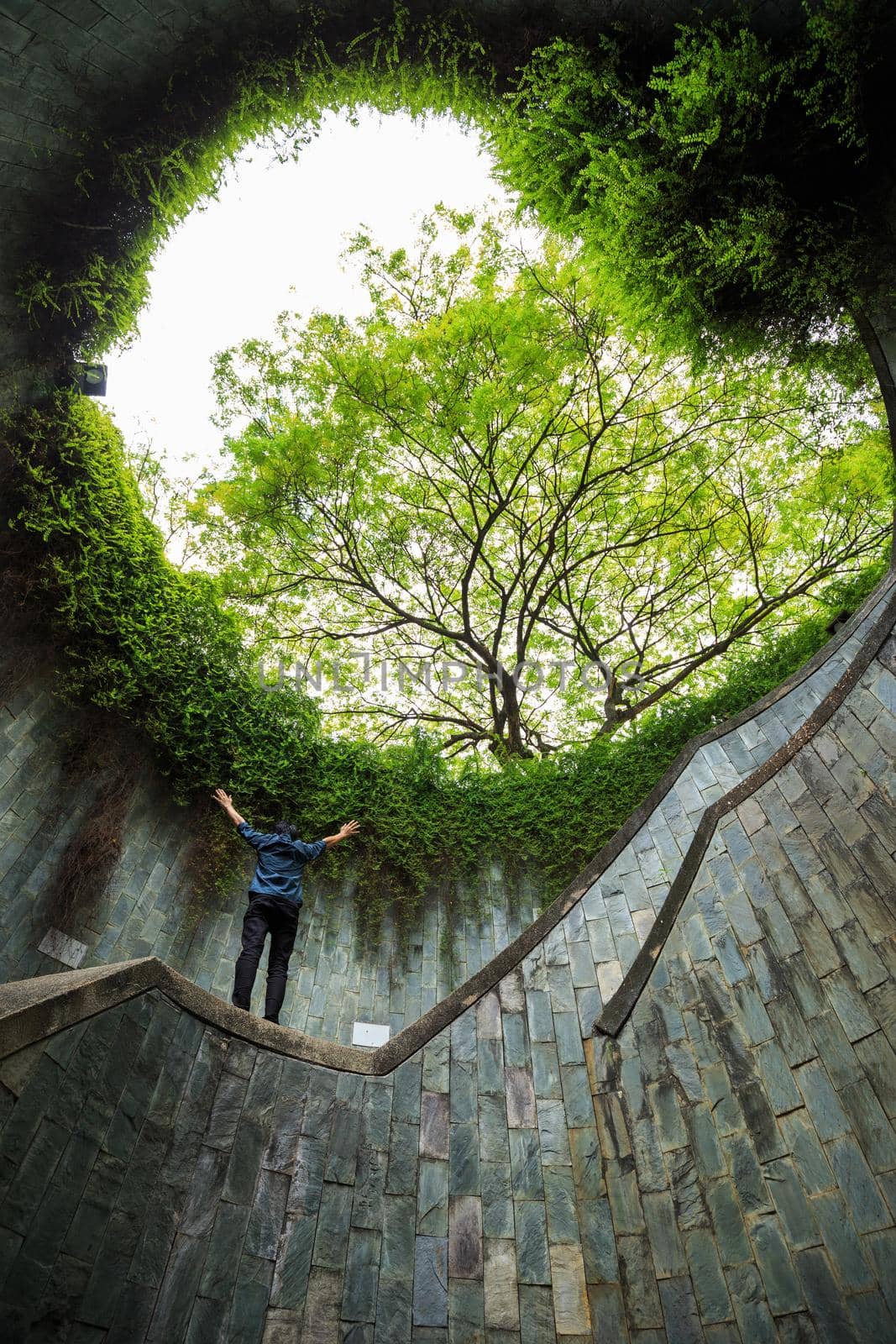 man hands up at underground crossing in tunnel at Fort Canning Park, Singapore