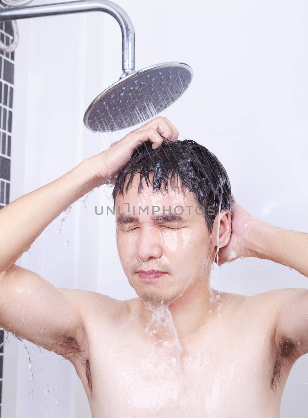 man are taking a rain shower in the bathroom