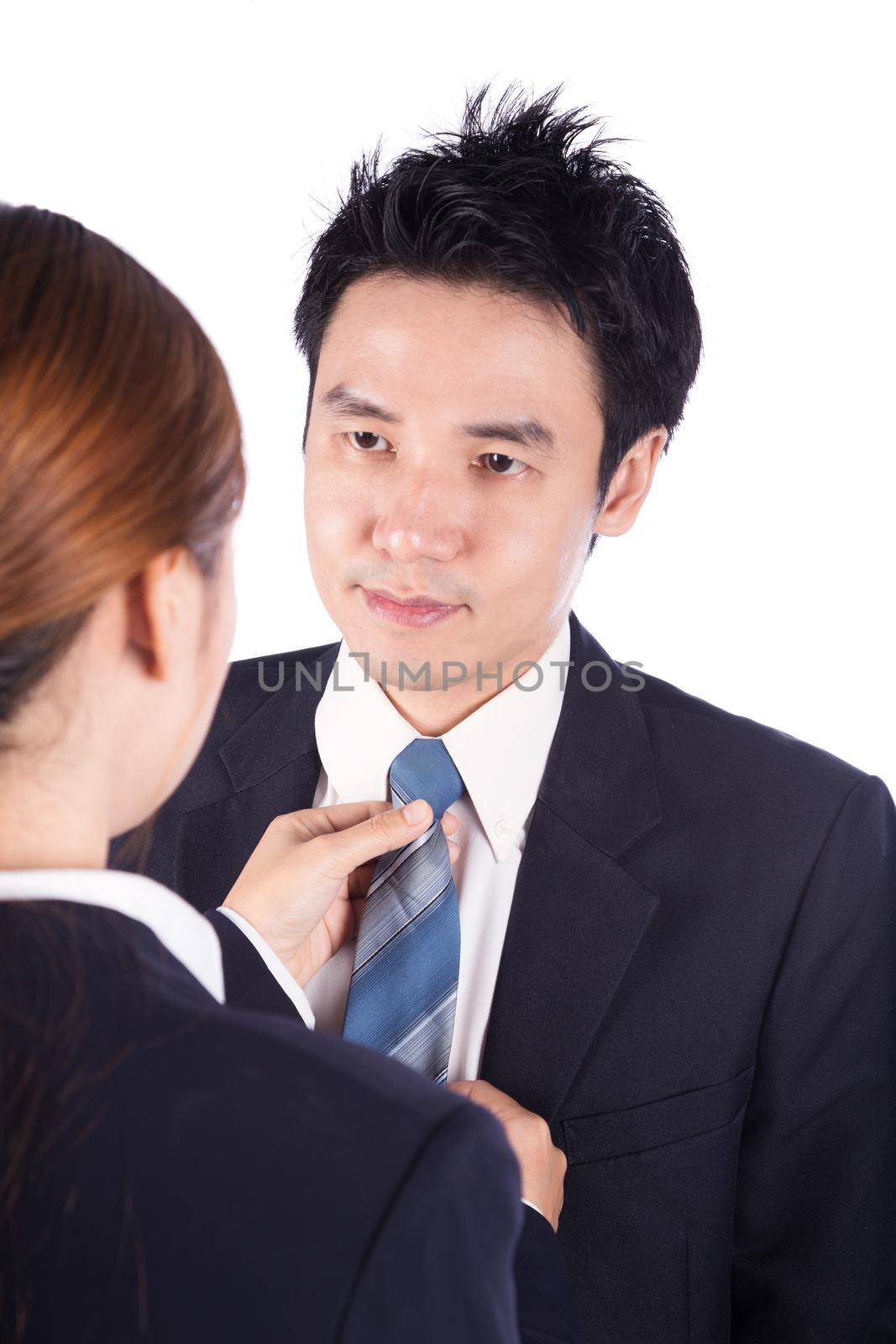 business woman's hands adjusting neck tie of man in suit isolated on white  by geargodz