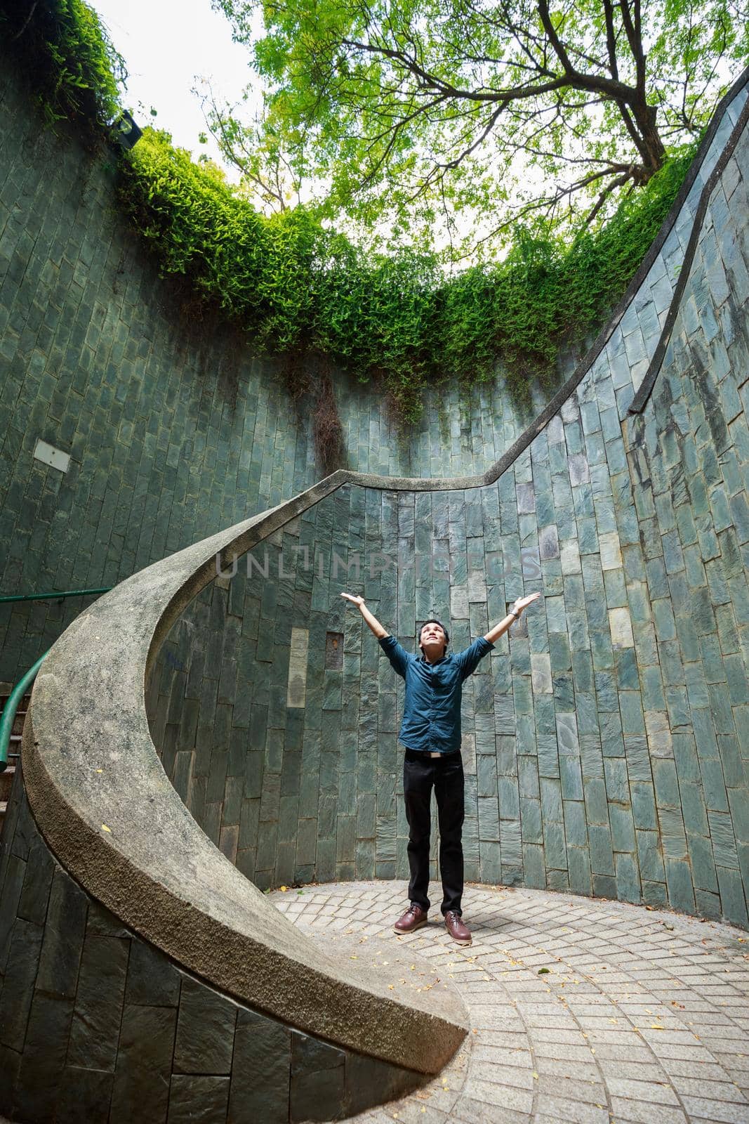 man hands up at underground crossing in tunnel at Fort Canning Park, Singapore