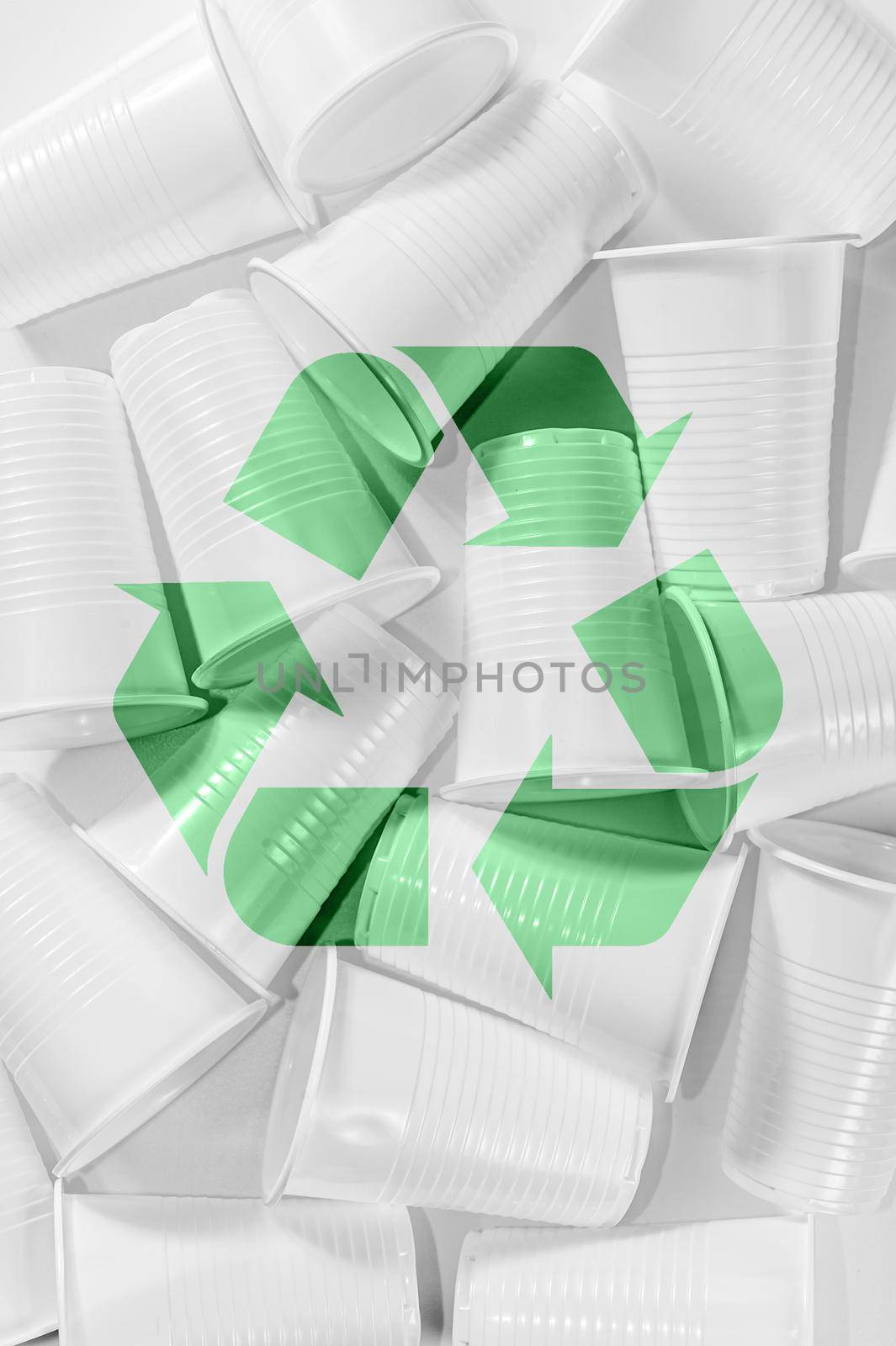 Several disposable plastic cups and recycling sing on a white background. Minimalistic ecologically clean still life. Green technology and ecology problem concept.