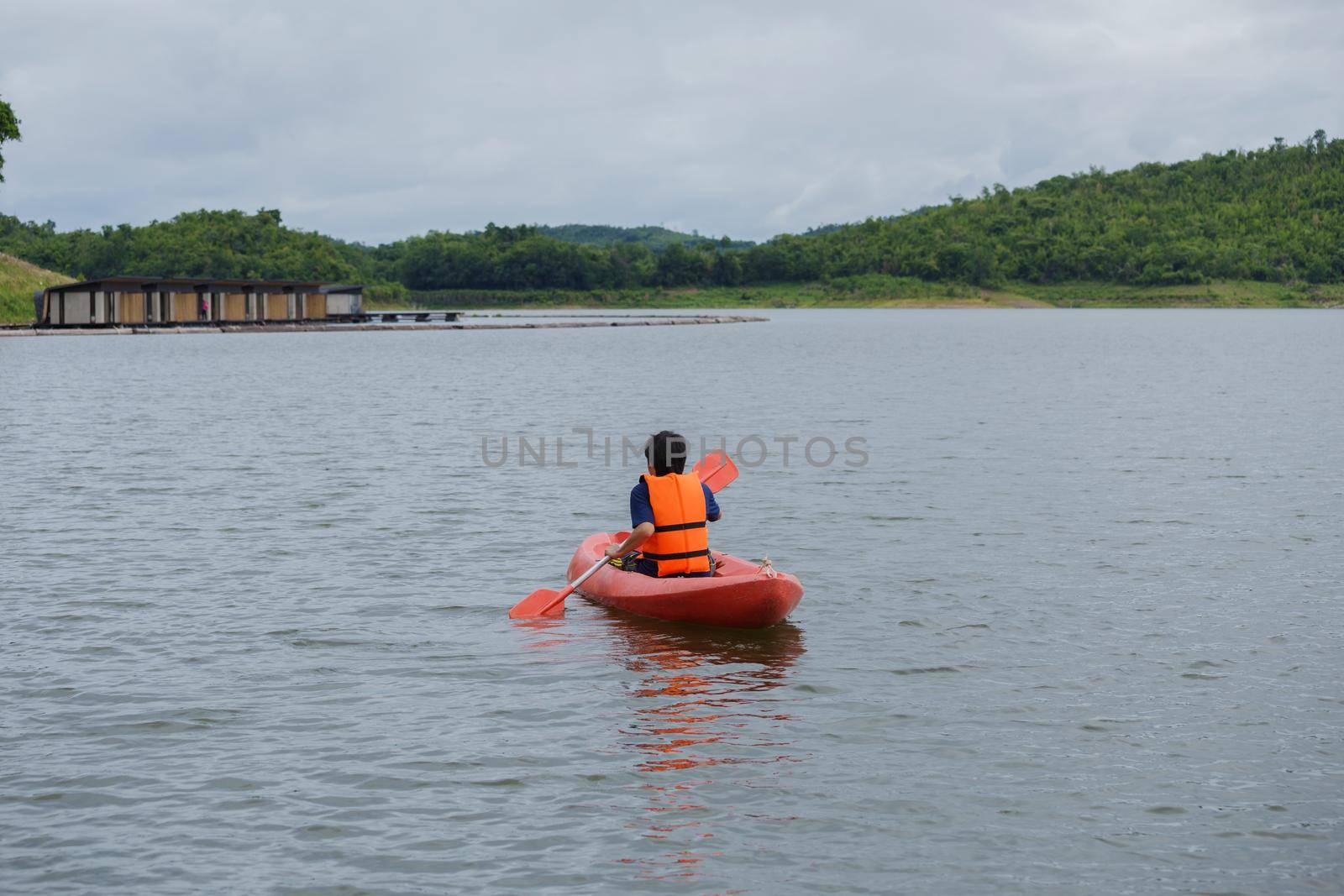 Man paddling in a red kayak boat in Thailand