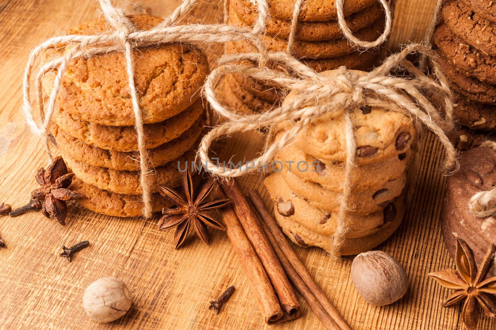 Various shortbread, oat cookies, chocolate chip biscuit and spice on dark rustic wooden table. by bashta