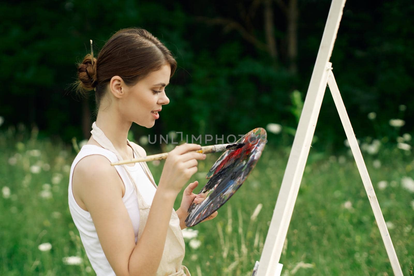 cheerful woman artist painting a picture outdoors creative art by Vichizh