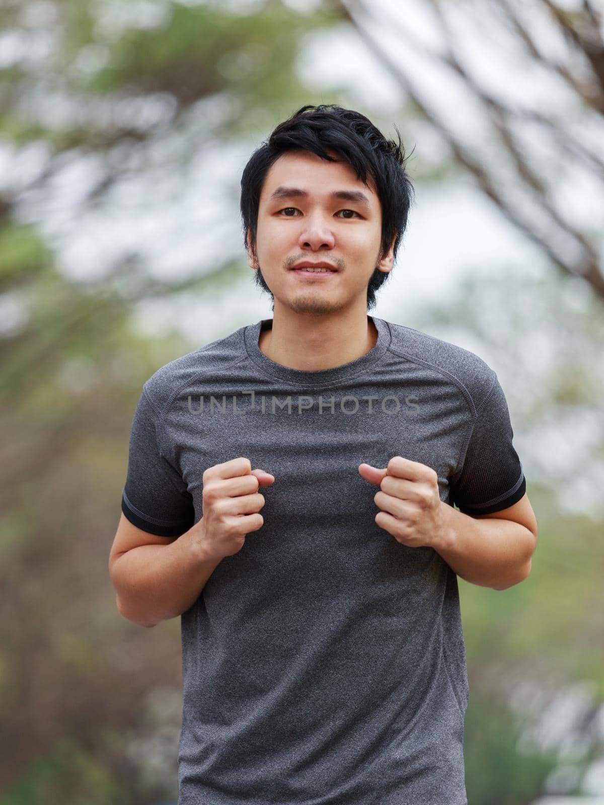 young fitness man running in the park