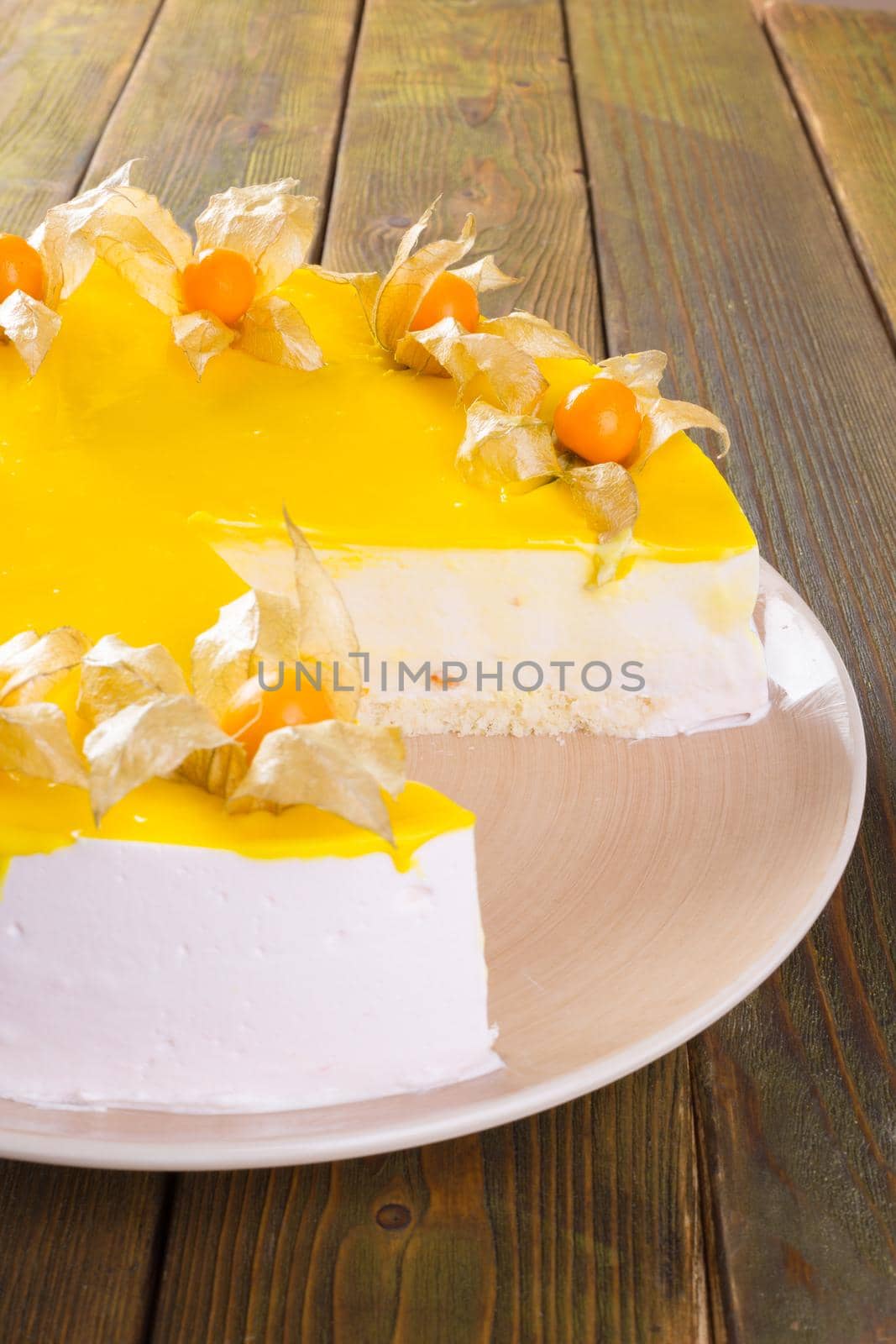 Cut cheesecake on plate on wooden table close up