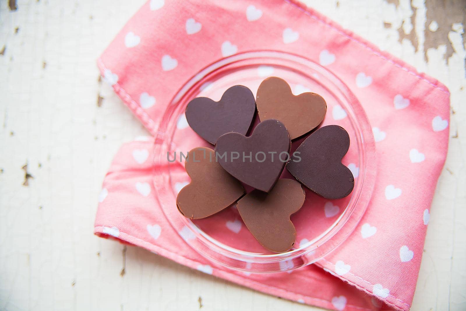 chocolate candy in the shape of a heart on a plate with pink towel by sfinks