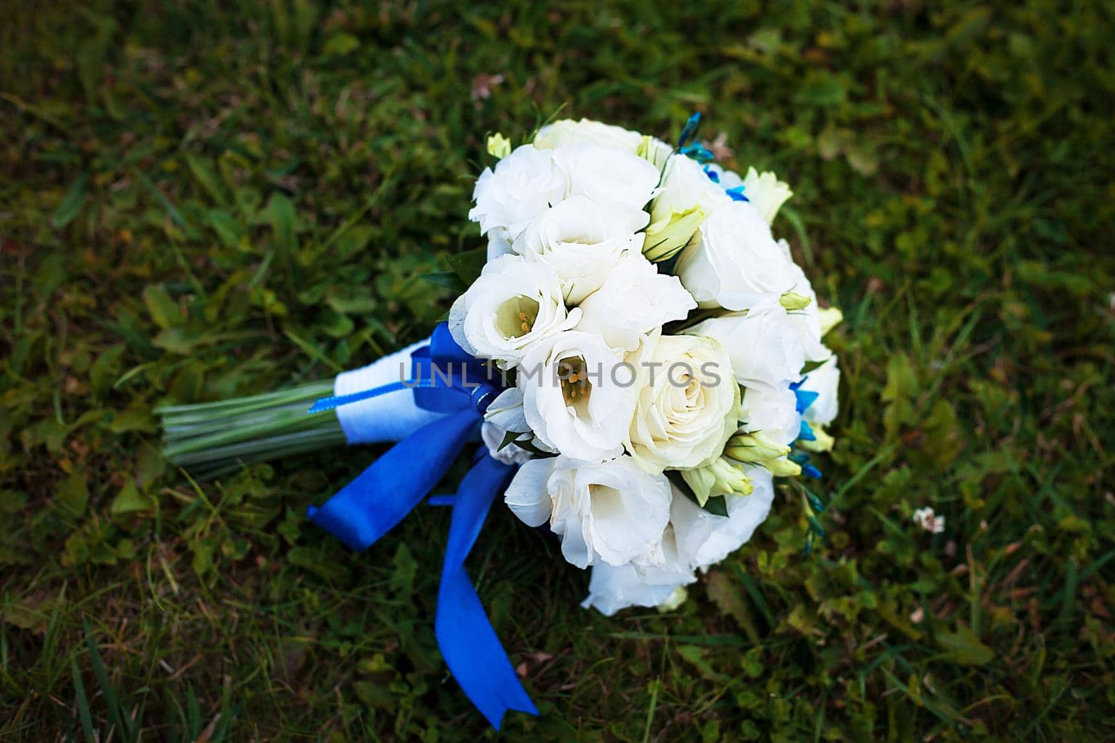 Bridal bouquet of various flowers on ground.