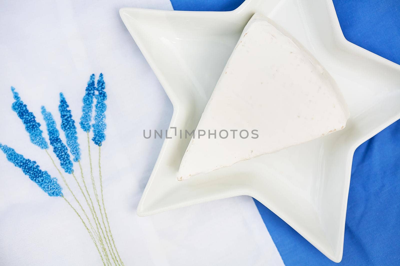 hat, brie cheese in a plate on blue tablecloth by sfinks