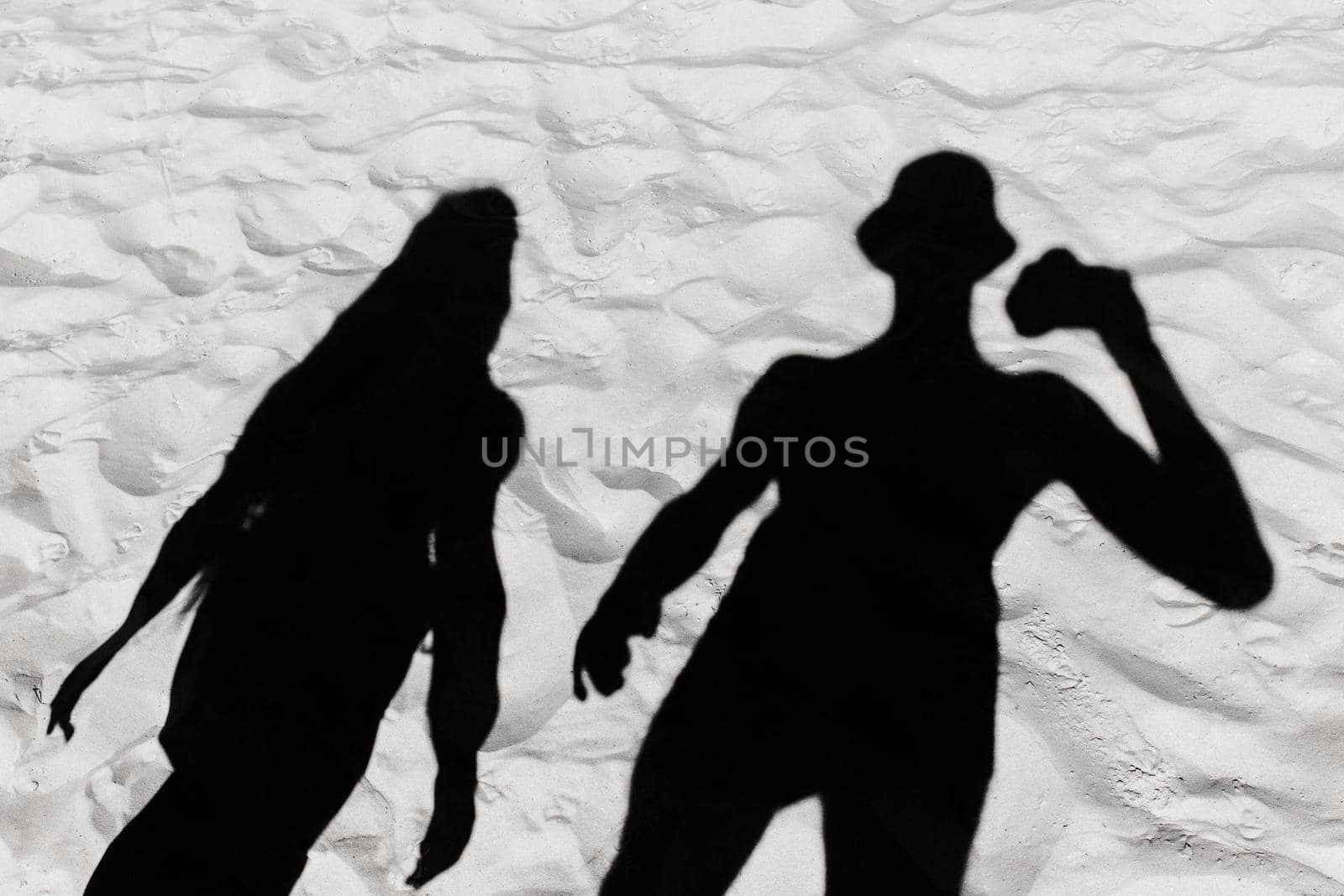 Dark black silhouette of a guy and a girl shade on a white beach sand background by AYDO8