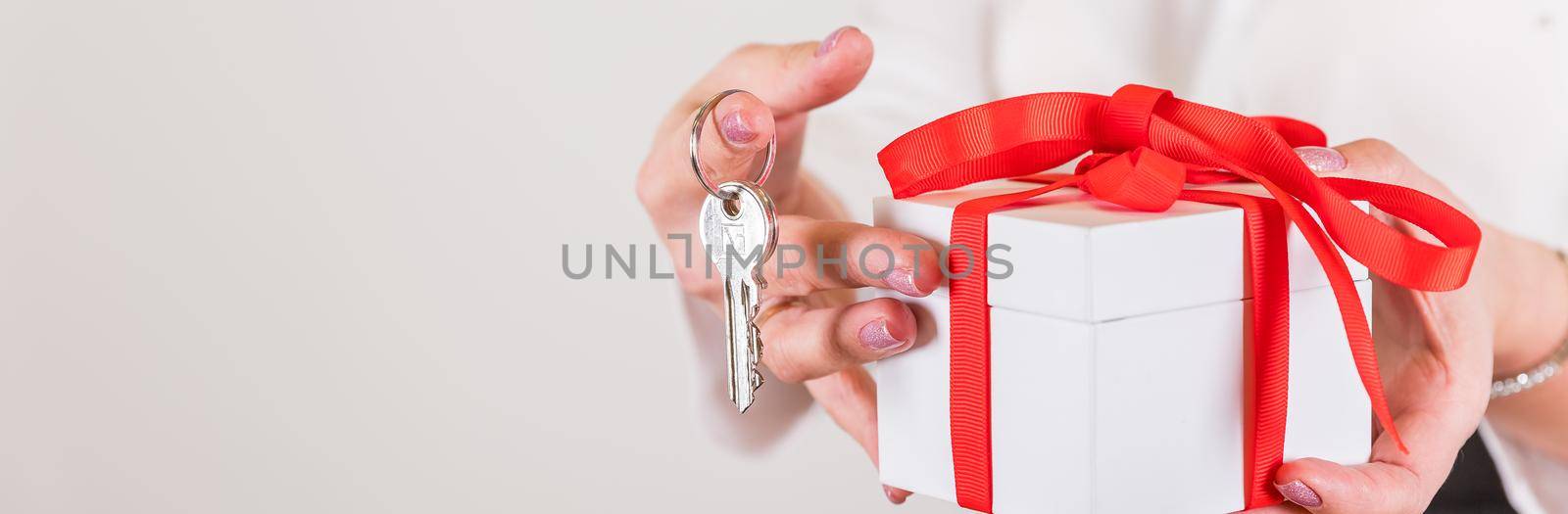 Female hands holding small gift with ribbon.