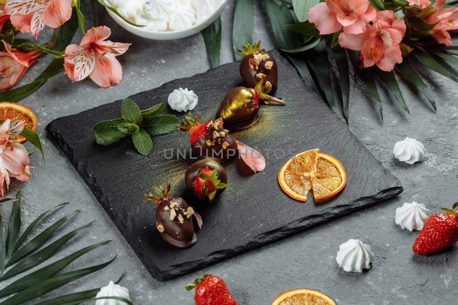 Fresh chocolate covered strawberries on a gray decorative background. Concept for advertising the summer seasonal menu.