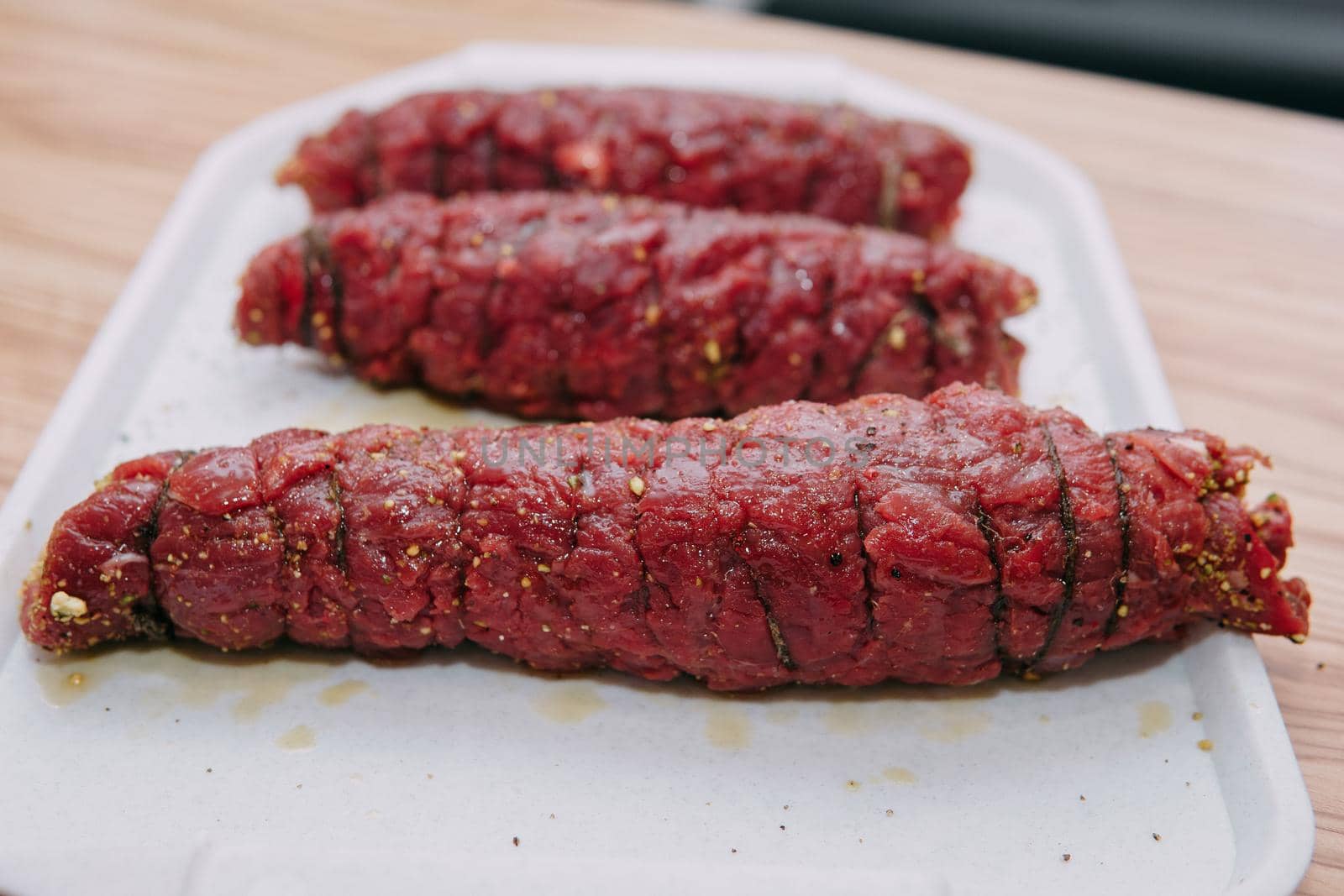 Cooking meat rolls in a cooking class. Beef roll with spices. Raw meat, close-up.