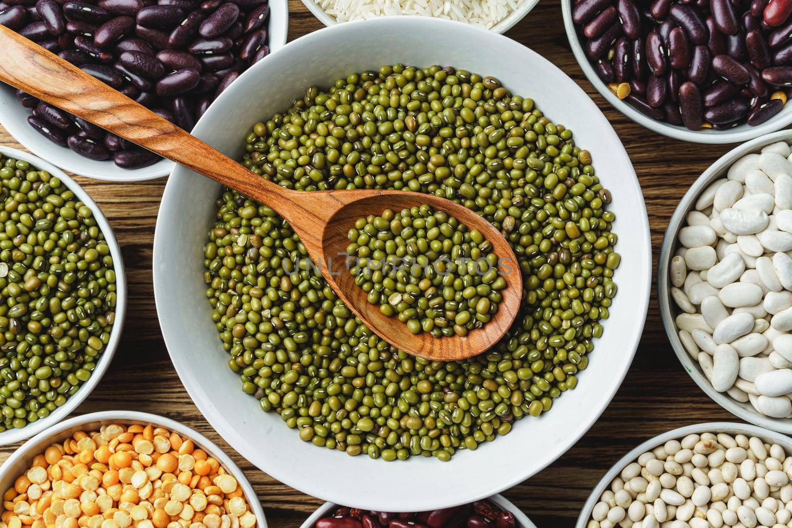 Assortment of beans on wooden background.