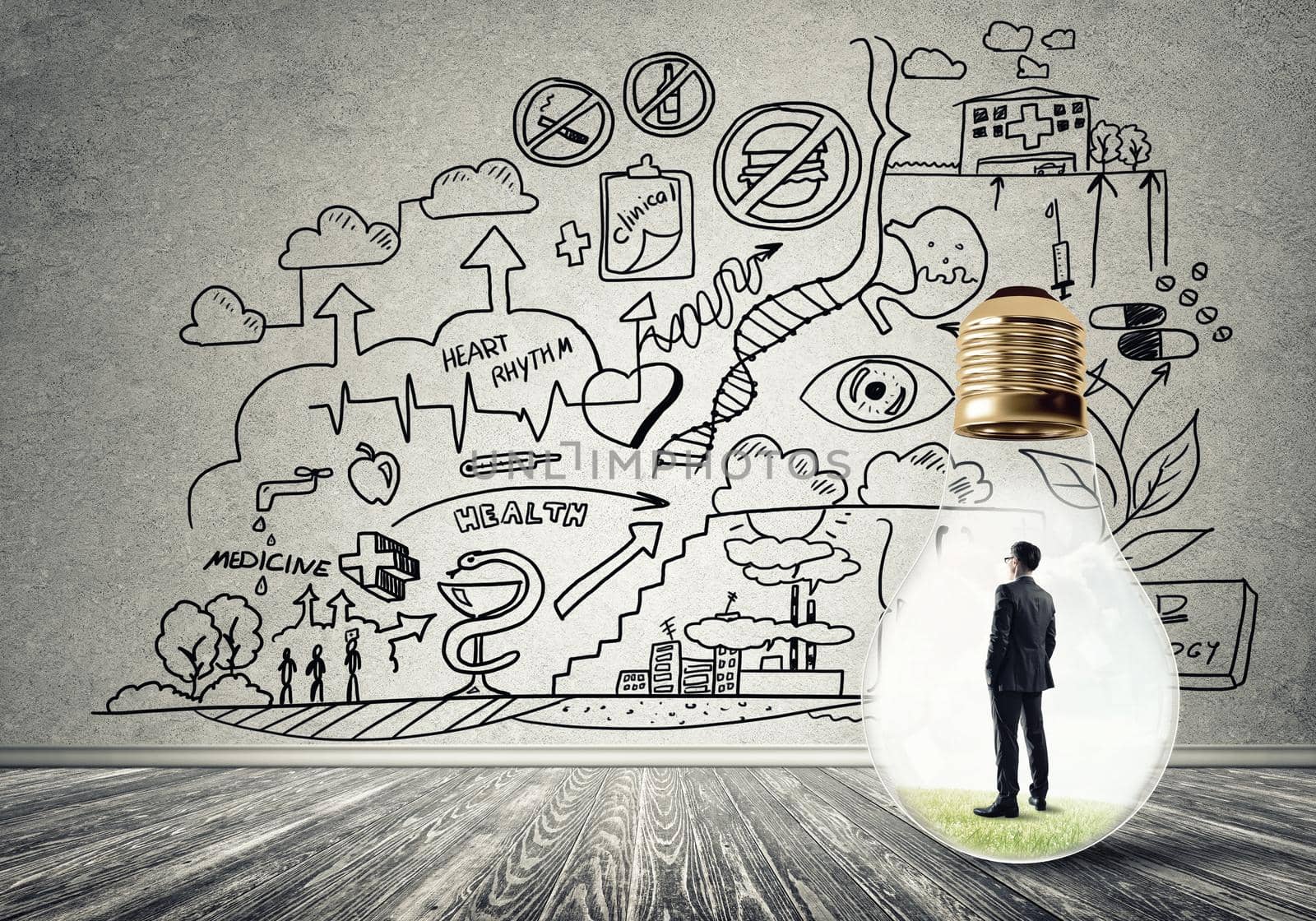 Businessman inside of light bulb in empty concrete room and sketches on wall