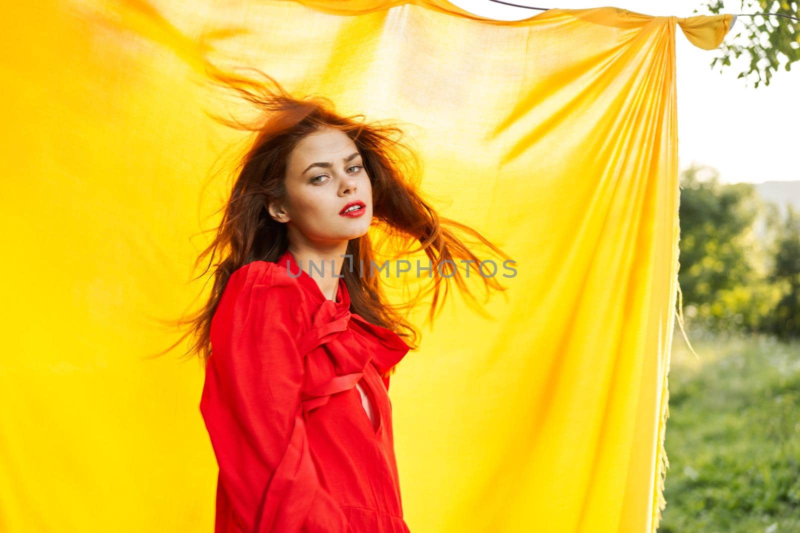 pretty woman in red dress outdoors nature yellow cloth. High quality photo