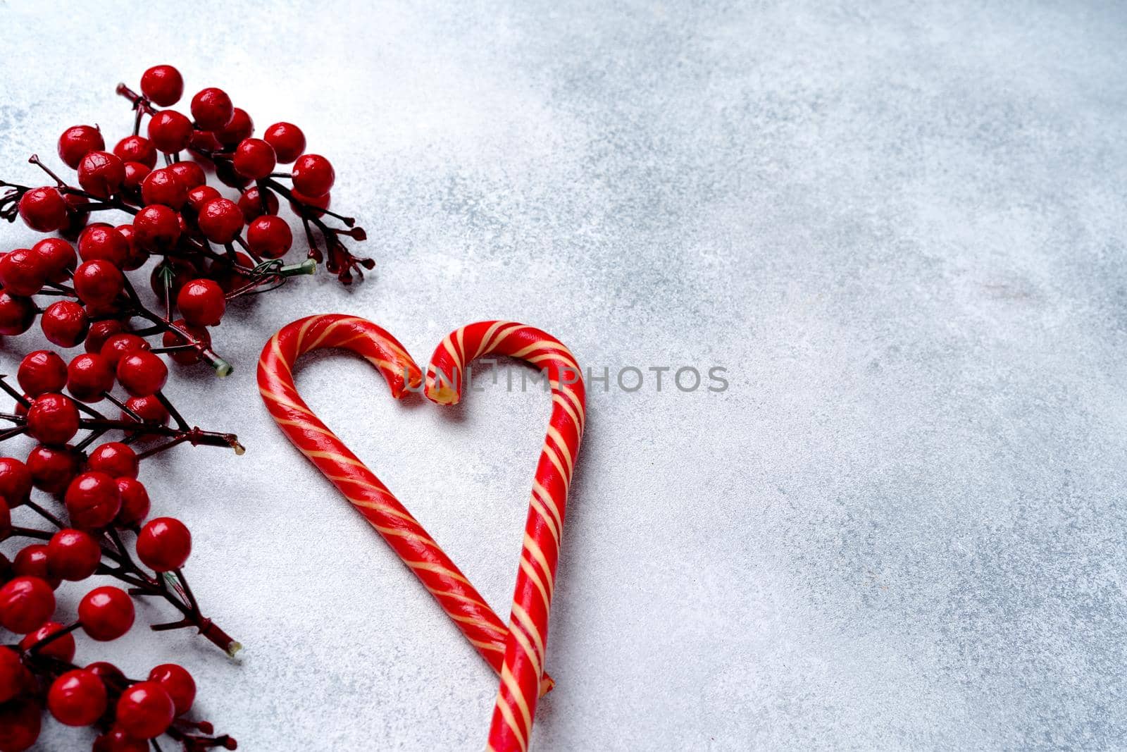 Candy canes on grey frosted background top view copy space