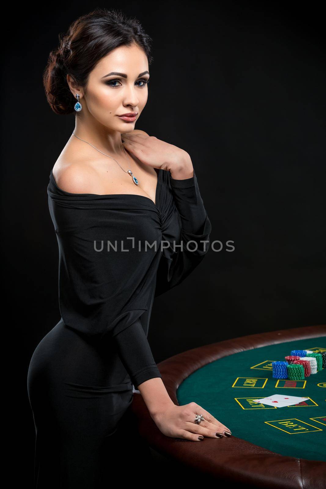 sexy woman with poker cards and chips. Female player in a beautiful black dress