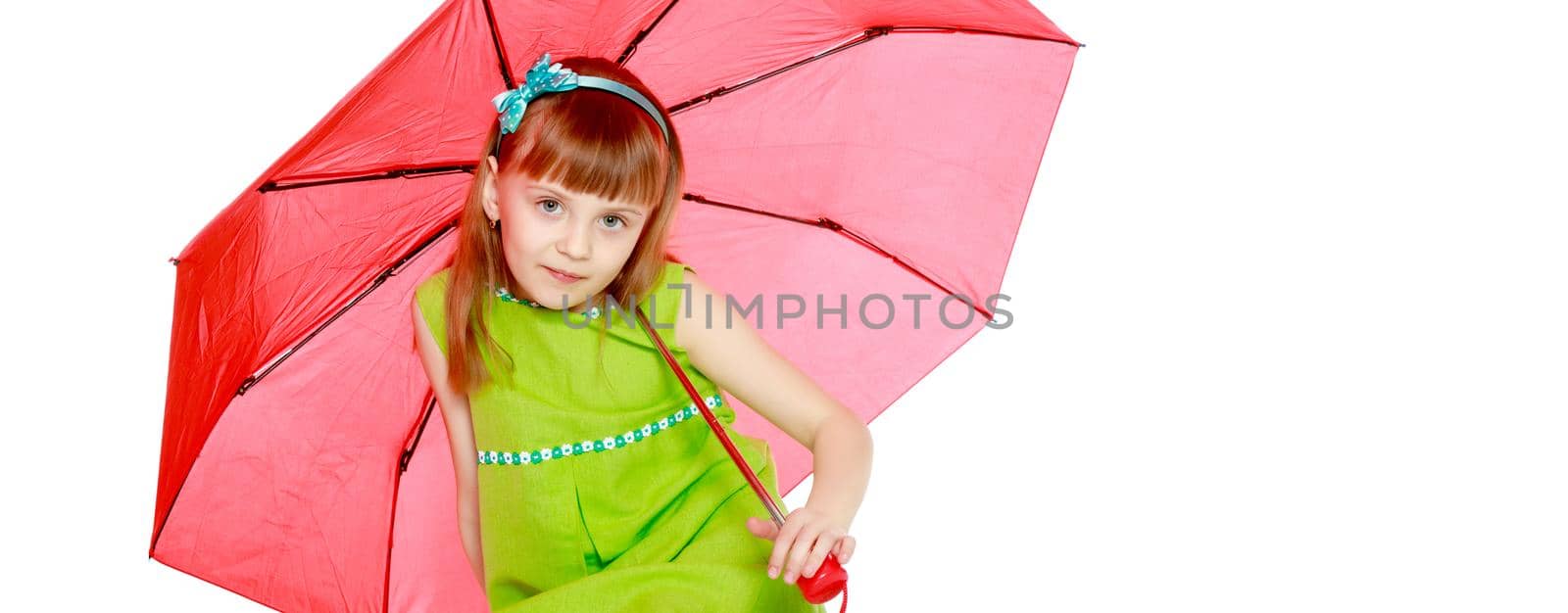 A little girl with long blond hair and a short bangs, in a short summer dress.The girl closed from the sun and rain under a red umbrella.