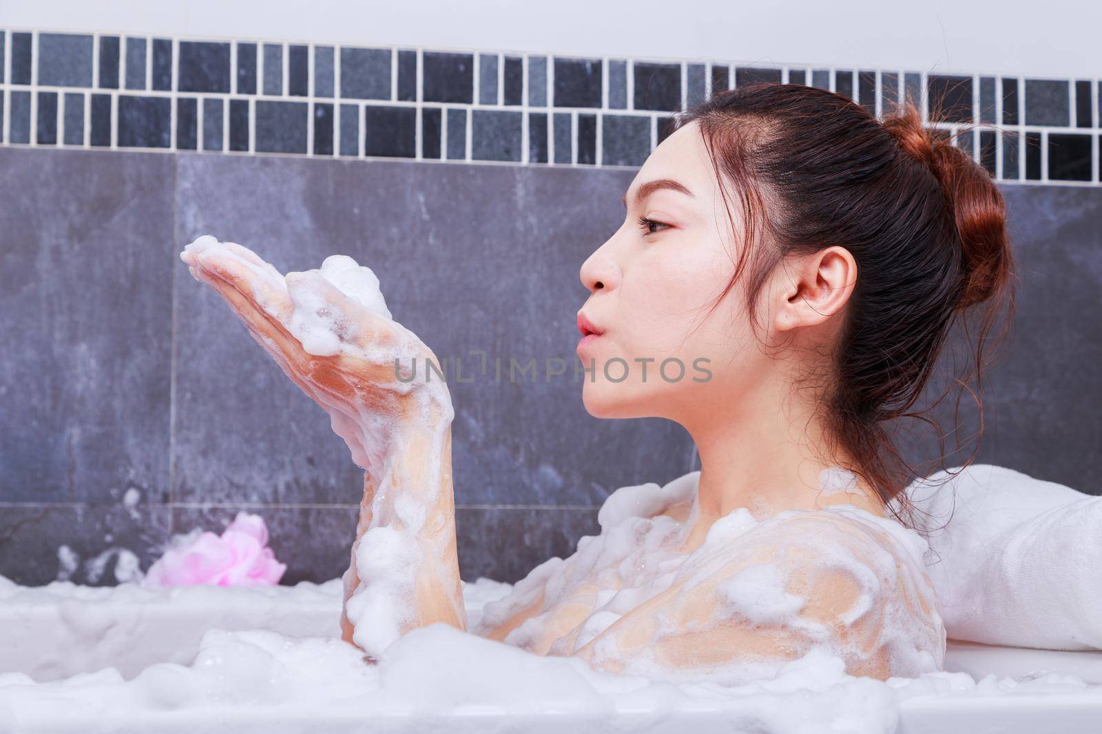 woman relaxing in the bathtub in the bathroom by geargodz