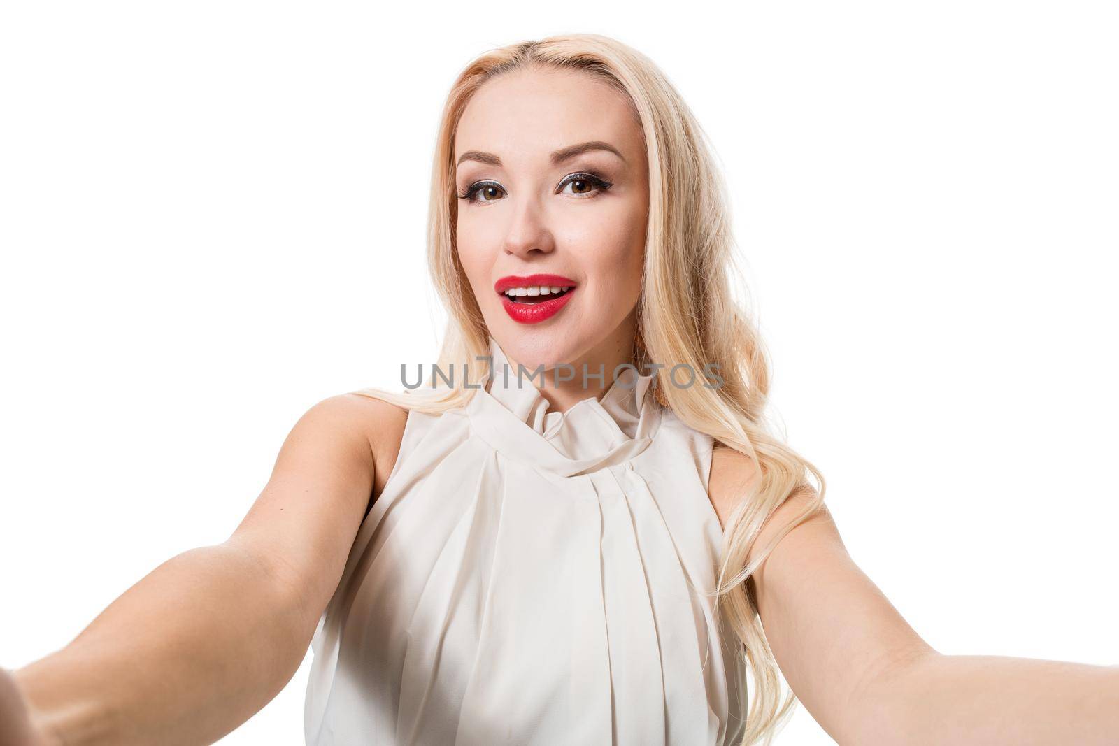 Smiling cheerful blond-haired woman doing selfie on isolated white background. Taking picture.