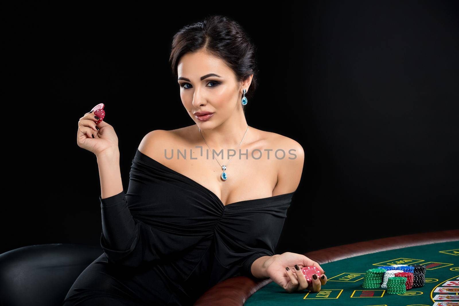 sexy woman with poker cards and chips. Female player in a beautiful black dress