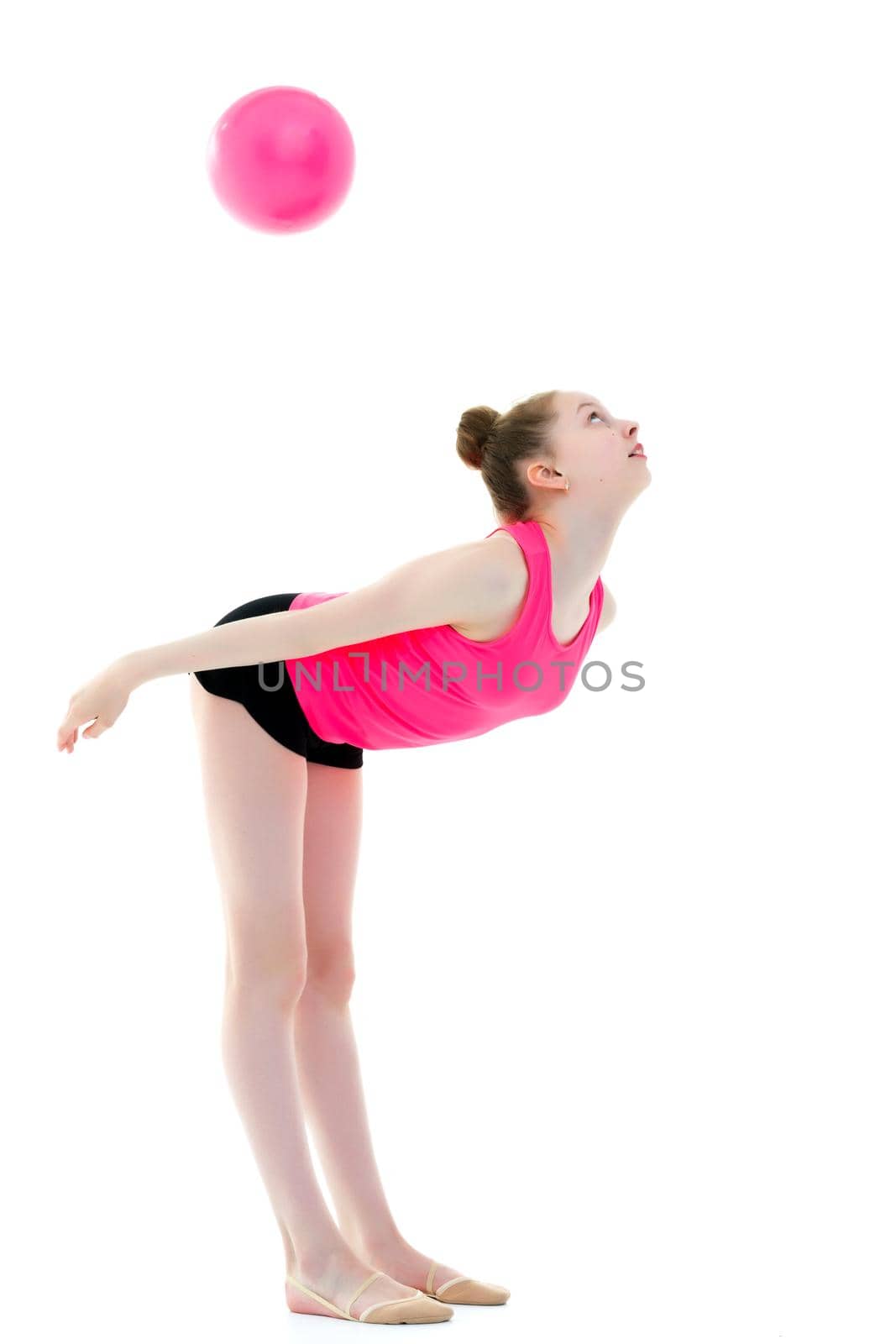 Beautiful little girl gymnast performs exercises with the ball. The concept of children's sports, fitness. Isolated on white background.