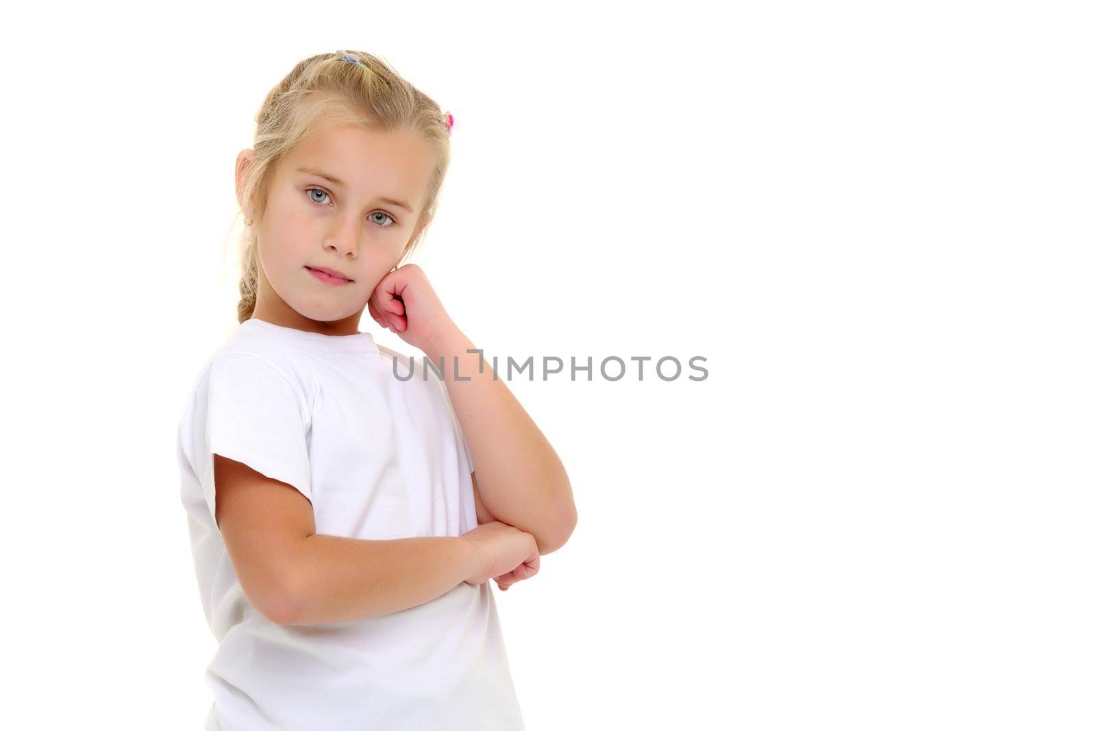 A little girl in full growth, in a pure white T-shirt and jeans. On the shirt you can put a logo or any other inscription. The concept of advertising on clothing, Happy childhood. Isolated on white background.