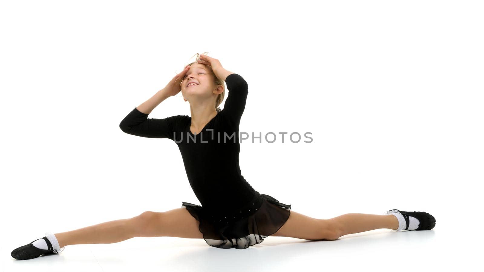 Slender girl gymnast doing the twine. The concept of children's sport. by kolesnikov_studio