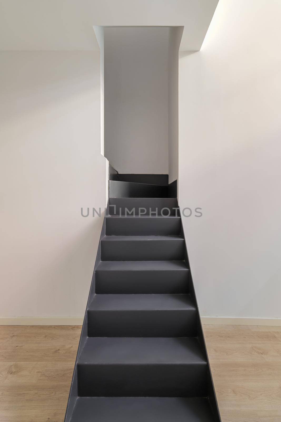 Black metal stairs leading to the second floor. Interior of empty renovated apartment in a duplex flat