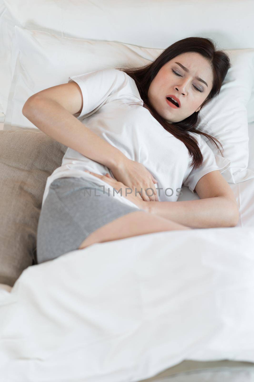 woman with stomach ache on a bed