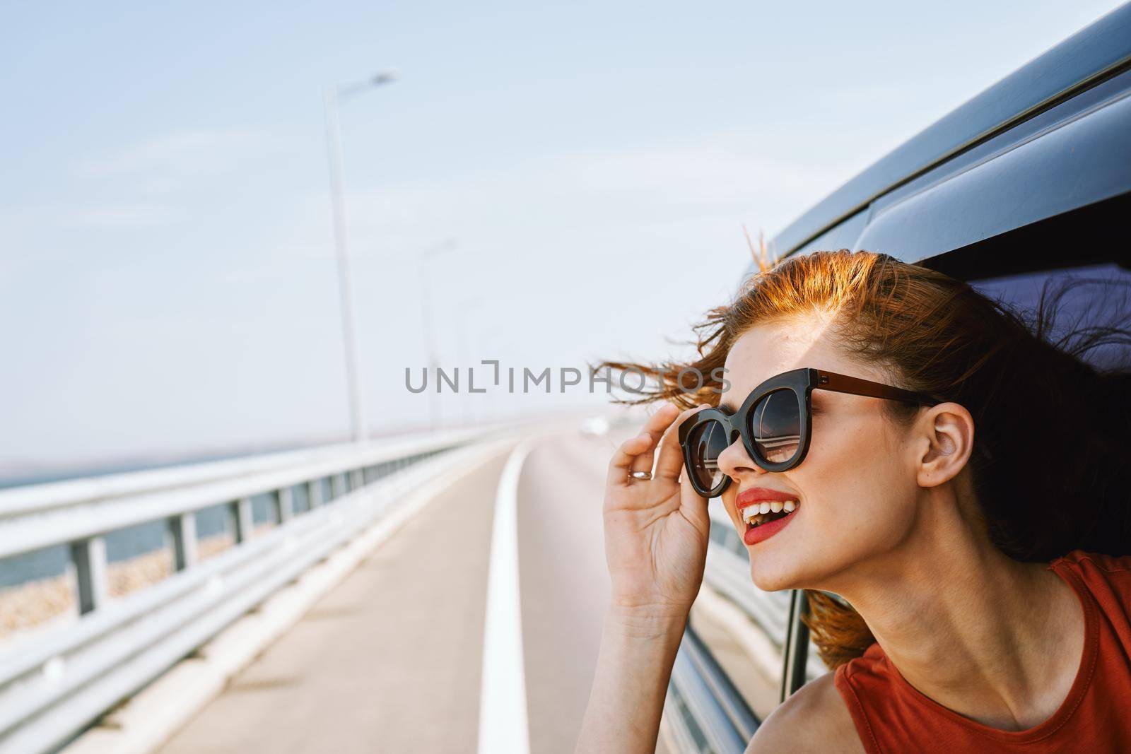 pretty woman in sunglasses rides in a travel car. High quality photo