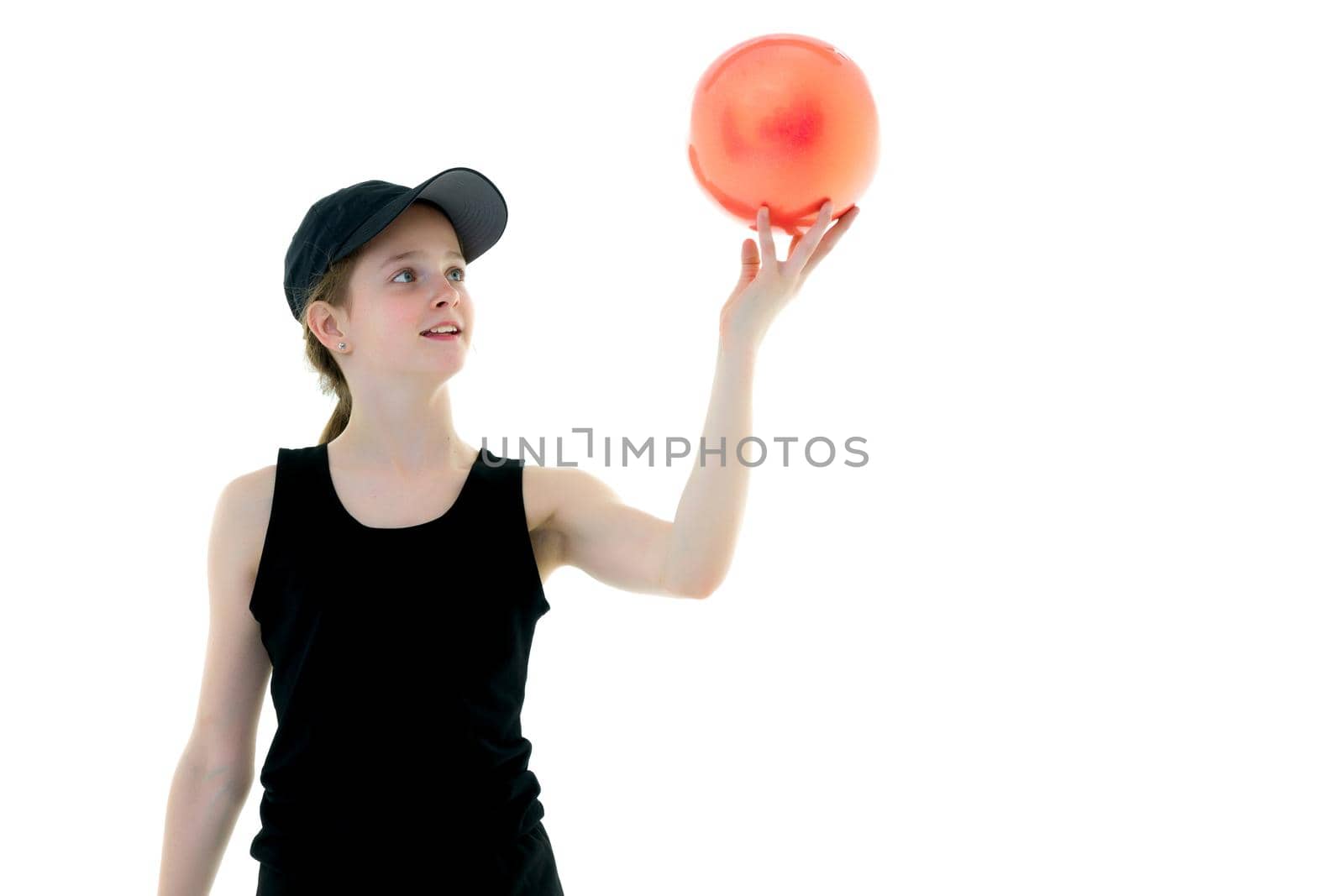 Beautiful little girl gymnast performs exercises with the ball. The concept of children's sports, fitness. Isolated on white background.