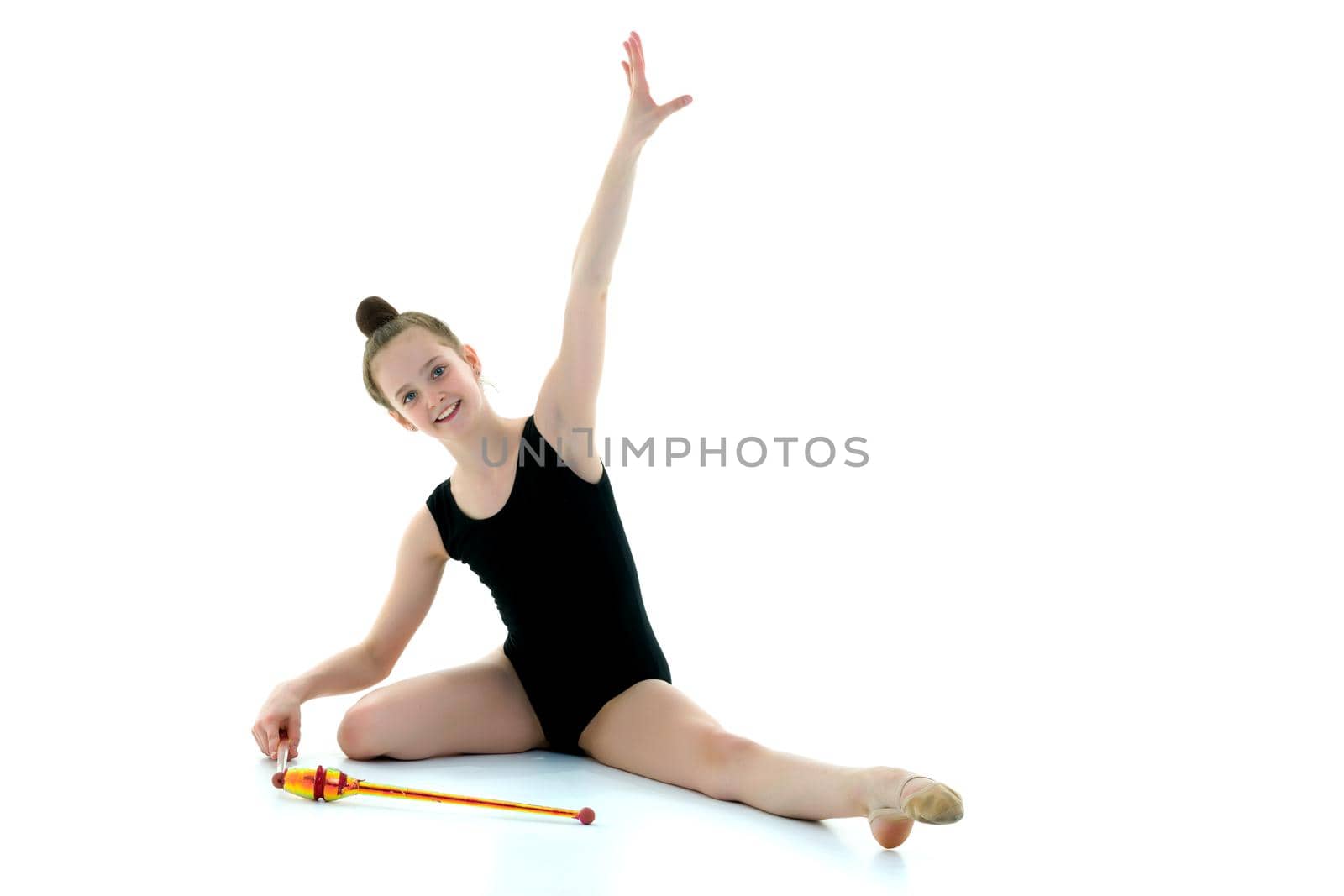 Beautiful little girl gymnast performs exercises with a mace. The concept of children's sports, fitness. Isolated on white background.