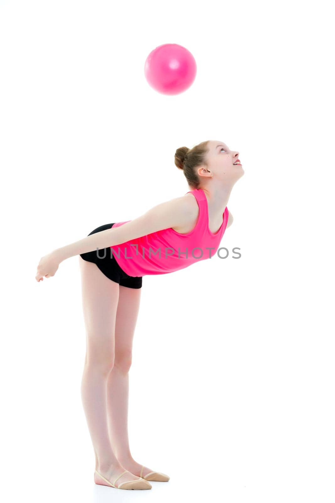 A charming little girl is engaged in fitness with a ball. The concept of gymnastics, health and sports. Isolated on white background.