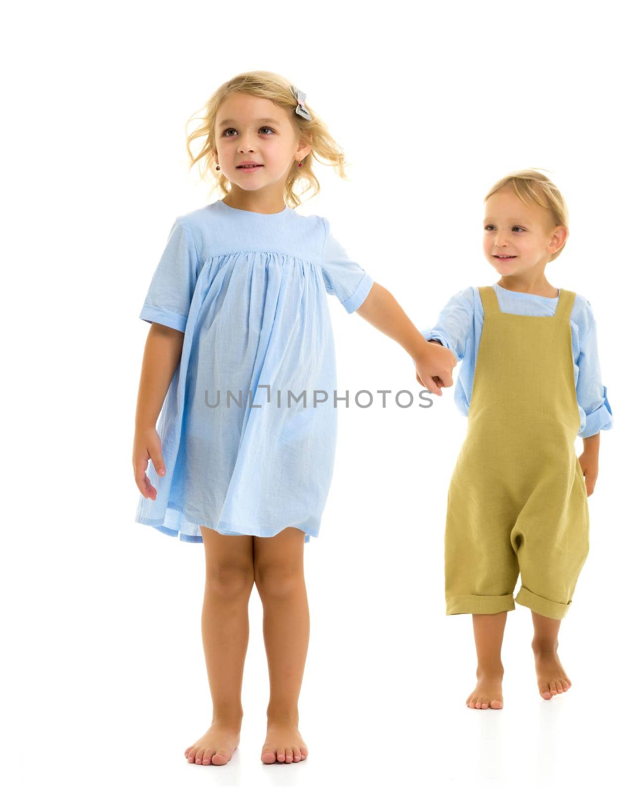 A boy and a girl are holding hands. The concept of friendship, happy childhood. Isolated on white background.