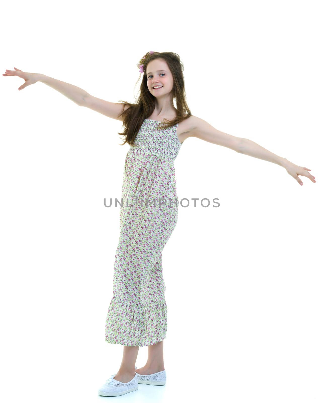 A strong wind blows on the face and clothes of a beautiful little girl of school age. Hair and clothes fluttering in the wind, and the girl is glad. Isolated on white background